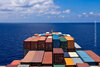 Auf dem Bild zu sehen sind Container auf einem Frachtschiff auf dem Meer mit blauen Himmel