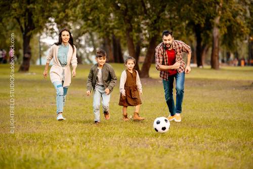 Junge Familie beim Fußballspielen